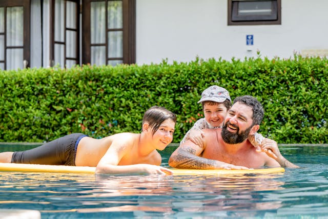 Une famille profite d'une piscine dans une belle villa